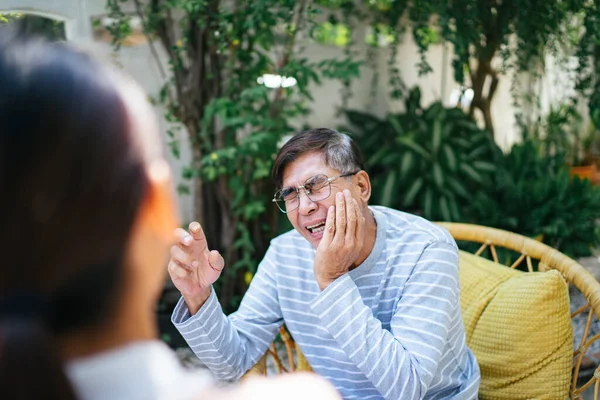 白髪の老人は彼の個人的な看護師に彼の痛みの状態について話す — ストック写真