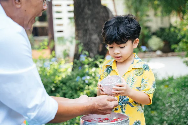 Menino Derramar Água Com Floral Mão Seu Avô Como Uma — Fotografia de Stock