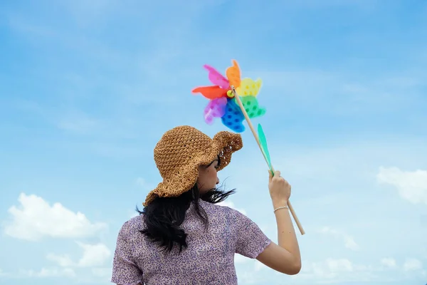 모자를 아래바람에 나부끼는 풍차를 귀여운 소녀의 — 스톡 사진