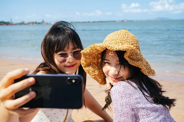 Two Girls Sitting Beach Sea Sunny Day Take Selfie Together — Stock Photo, Image