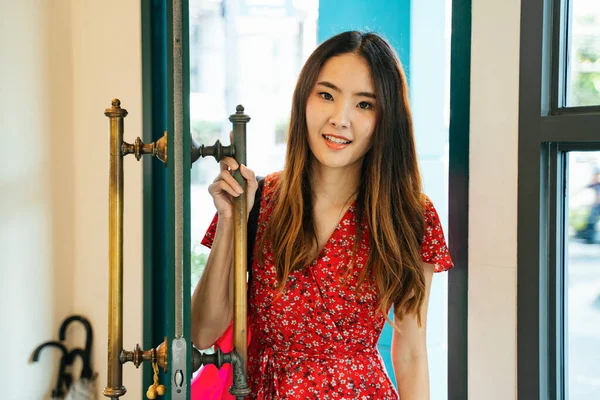 赤のドレスの陽気な若いアジアの女性は ドアに立って ヴィンテージカフェに入ります — ストック写真
