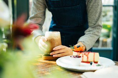 Barista, peynirli kekle birlikte buz gibi kahve yapıyor..