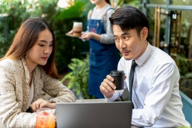 Asyalı iş adamları ortak olarak kahve dükkanında bilgisayara bakıyorlar. İlk görüşte aşk.