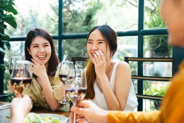 İki iyi arkadaş bardaktan şarap içmeyi sever. Bir grup neşeli arkadaş ellerinde içkilerle kutlama yapıyorlar..