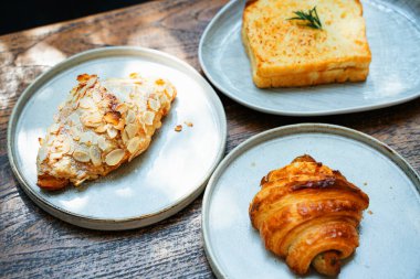 Üç çeşit ekmek. Tabakta ekmek ve kruvasan kızartıyorum. Kafede karbonhidrat.. 