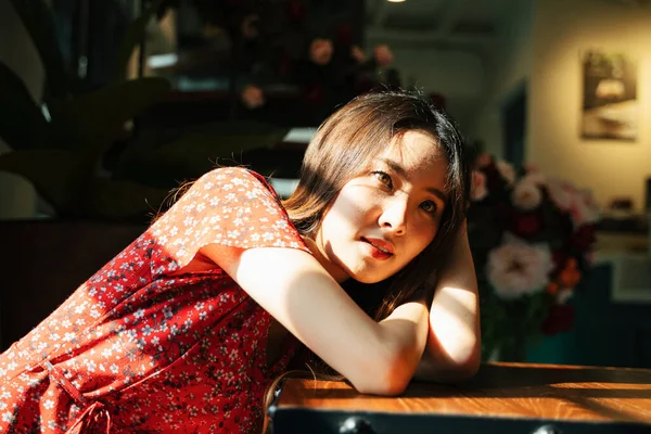 Молода Азіатська Тайська Жінка Червоній Сукні Лежить Столі Всередині Будинку — стокове фото