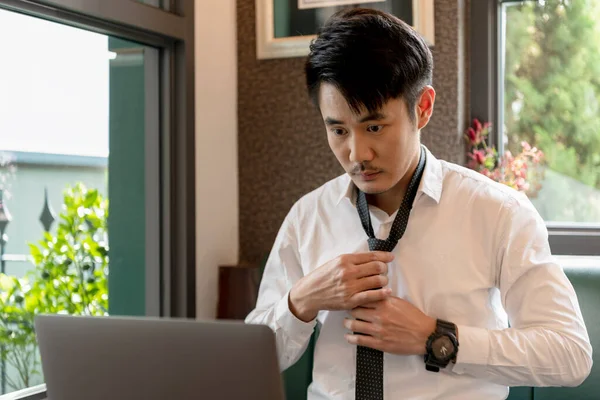 身穿白衬衫领衫的亚洲商人在笔记本电脑前打扮自己 工作和穿衣 — 图库照片