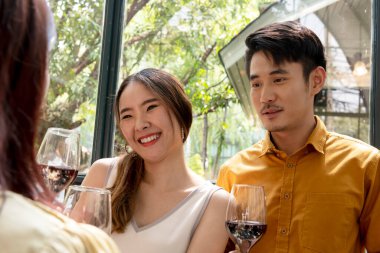 Asyalı çift partide şarap içmeyi sever. Kırmızı şaraptan hoşlanan romantik bir çift. Kırmızı şarap kadehleriyle kutlama ve tezahürat yapmak.