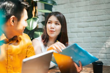 İki Asyalı ortak çalışma alanında iş görüşmesi planını tartışıyor.