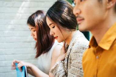 Güzel Asyalı kadın diğer adaylarla birlikte odanın dışında röportaj için bekliyor. Endişeli ve gergin adaylar röportaj için geldiler ve çözüm için beklediler. Ofiste CV 'leriyle sırada oturup röportaj sırasının kendilerine gelmesini bekliyorlar..