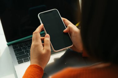 Akıllı telefon ve dizüstü bilgisayarla evden öğrenci çalışması.