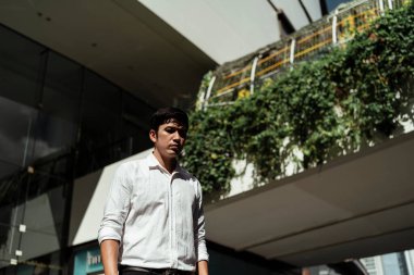 Şirketten ayrıldıktan sonra sokakta yürüyen Asyalı ciddi bir iş adamı..