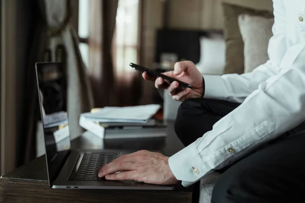 사업가가 책상에 앉아서 스마트폰을 노트북 사용하고 있습니다 노트북 태블릿 컴퓨터가 — 스톡 사진