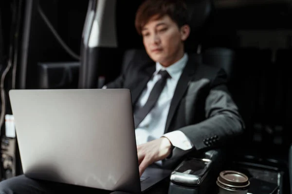 英俊的亚洲商人坐在豪华豪华轿车里 在笔记本电脑上工作 — 图库照片