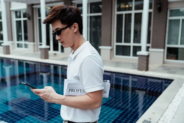 Smart Azjatycki Biznesmen Okularach Przeciwsłonecznych Podróży Służbowej Pomocą Smartfona Pobliżu — Zdjęcie stockowe