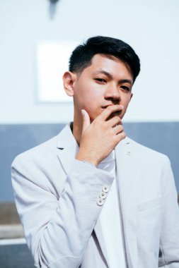 Beyaz takım elbiseli bir adam TV dizisinin başrol oyuncusu gibi davranıyor..