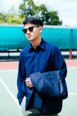 Solucan bakışı, açık gökyüzünün altında güneş gözlüklü koyu mavi bir adamın görüntüsü..