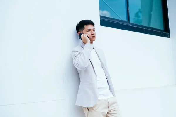 Muž Bílém Obleku Sedí Budově Mluví Někým Telefonu — Stock fotografie