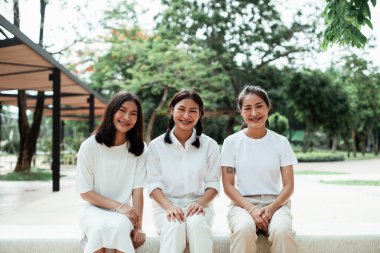 Parktaki oyun parkında mermer bankta oturan üçlü ikiz kardeş..