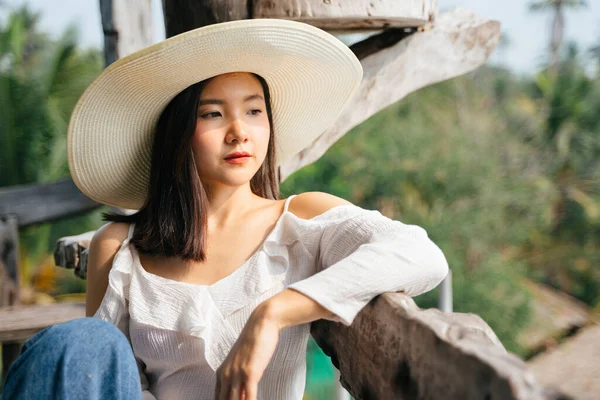 Beyaz Tişörtlü Asyalı Kadın Kırsal Kesimde Bankta Oturan Şapkalı — Stok fotoğraf
