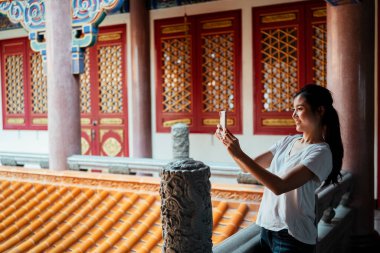 Akıllı telefon kullanan, selfie çeken, akıllı telefondan video bloğu yapan seksi Asyalı kadın..