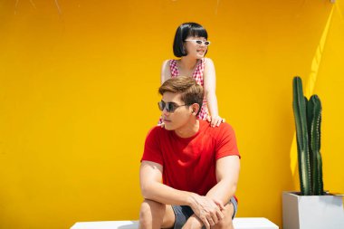 Turuncu arka planda yaz tatili yapan birkaç Asyalı genç..