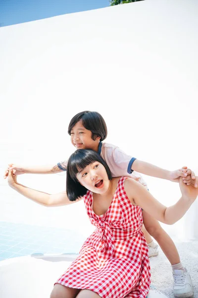 Hermana Jugando Con Hermano Pequeño Haciendo Avión Posando Sobre Fondo —  Fotos de Stock