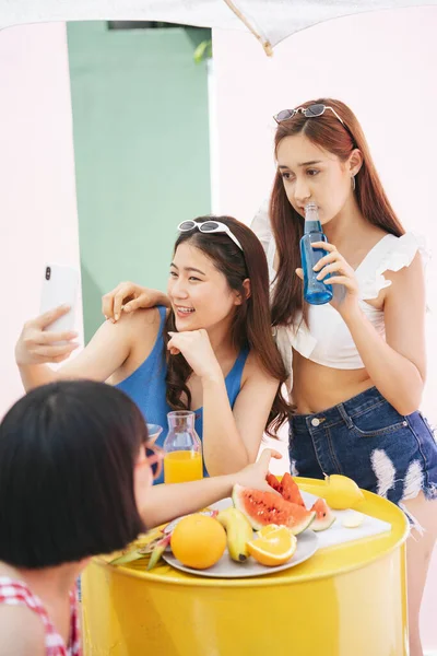 女性は夏のパーティーでスマホで自撮り 人々のグループはパーティーを楽しむ — ストック写真