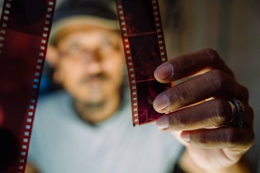 Bir adam fotoğraf çekmeden önce kameradan filmi kontrol ediyor..