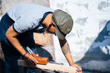 Sanatçılar kalası ölçüp inceltmek için tıraş aletini kullanırlar..