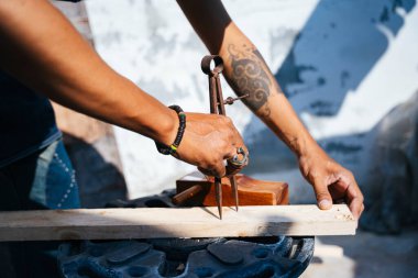 Zanaatkarlar kalası ölçer ve kalasları ince yapmak için traş aletini kullanır..