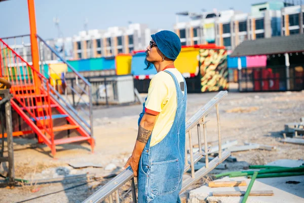 Man Yellow Shirt Denim Overalls Standing Abandoned Amusement Park Sunny — Stock Photo, Image