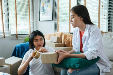 Oturma odasında iki Taylandlı kız paketini paketliyor. Müşteri alışverişine göndermek için..