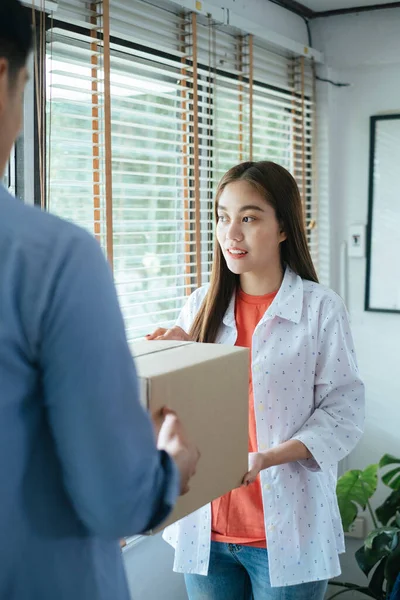 Long hair woman give the parcel to her partner then he will bring all the parcels to post office and send to the customers.