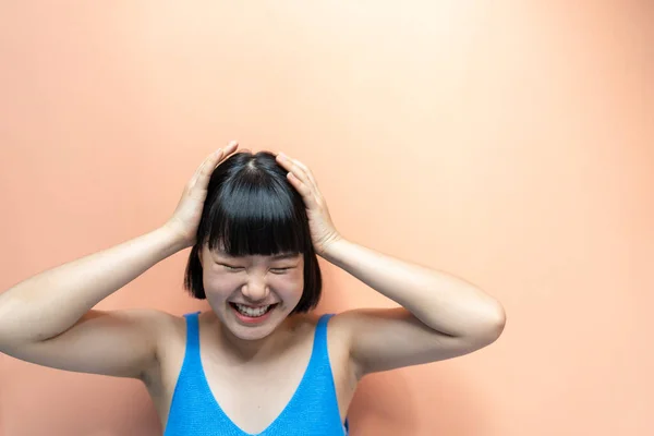 아시아 여자는 야만성 배경에서 행복으로 미소짓는 모양을 손으로 머리를 — 스톡 사진