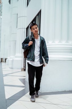 Kısa saçlı adam, öğleden sonra randevu yerine giderken güzel beyaz binanın önünden geçiyor..