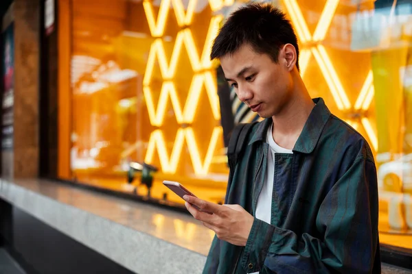 Krátké Vlasy Chlap Stojí Před Šaty Shop Oranžovým Neonovým Světlem — Stock fotografie