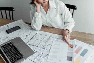 Proje binası için fayans seçmeye odaklanırken kadın iç mimarın kırpılmış görüntüsü.