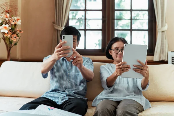 Linda Pareja Ancianos Sentados Sofá Sala Estar Mirando Teléfono Inteligente —  Fotos de Stock