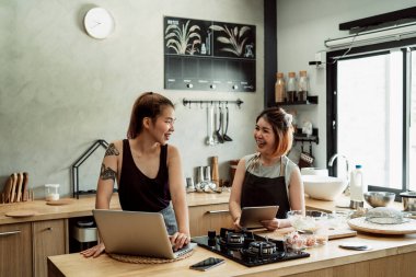 Asyalı fırıncı kadınlar mutfakta birbirleriyle konuşuyorlar. Yeni şeyler yaparak eğleniyorum. Yeni menü oluşturuluyor.