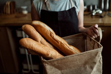 Fransız ekmeğini, kadın müşterilerin taşıdığı kumaş torbanın içinde kapat..
