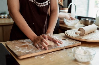 Kadın pasta şefi mutfakta ekmek hamuru yoğuruyor. Un ve tereyağlı yemek yapmak. Ellerle ekmek hamuru yapmayı. Yemek pişirme prosedürü.