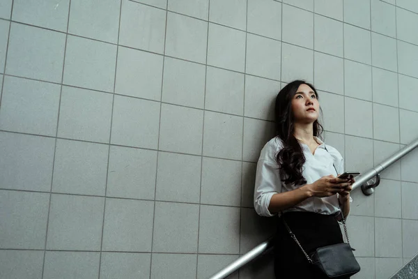 Beyaz Tişörtlü Asyalı Umutsuz Kadını Metro Merdiveninde Akıllı Telefon Tutuyor — Stok fotoğraf