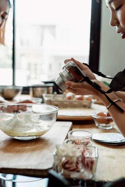 Young asian baker women doing cooking show recording video with camera. Cooking Vlog by LGBTQ people in the kitchen. Making bread. Cheerful two asian baker women making bread dough.