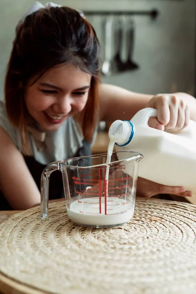 통조림통에서 나오는 우유를 주방에서 측정되는 유리병에 브라질 요리사 — 스톡 사진