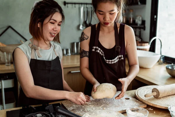 Woman pastry chef kneading bread dough on worktop in kitchen. Cooking with flour and butter. How to make bread dough with hands. Cooking procedure.