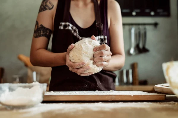 Close up hand of woman pastry chef baker kneading bread dough on worktop.