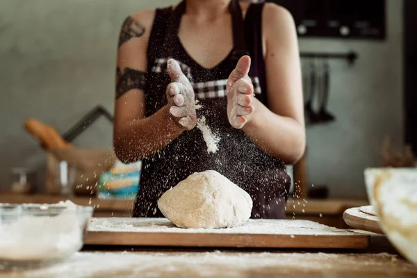 Asian pastry chef baker woman sprinkle flour on bread dough. Making bread procedures. Cooking scene.