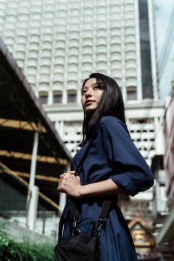 Kendine güven ve bağımsızlık. Mavi elbiseli güzel Asyalı kadın. Eski semtteki şehre seyahat ediyor..