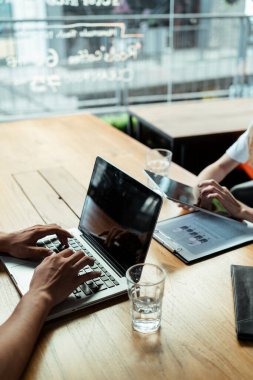 Kafede ya da modern ofiste çalışan bir adamın laptopunda daktilo yazarken elini kapat..